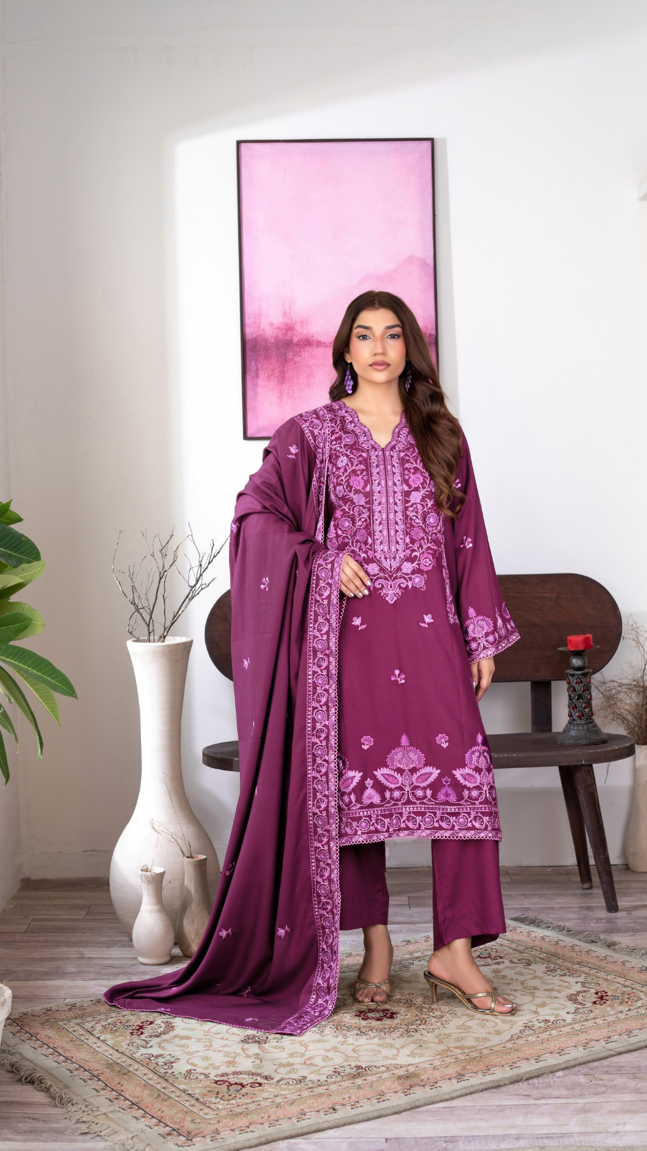 A woman models a traditional South Asian outfit consisting of a deep purple kurta