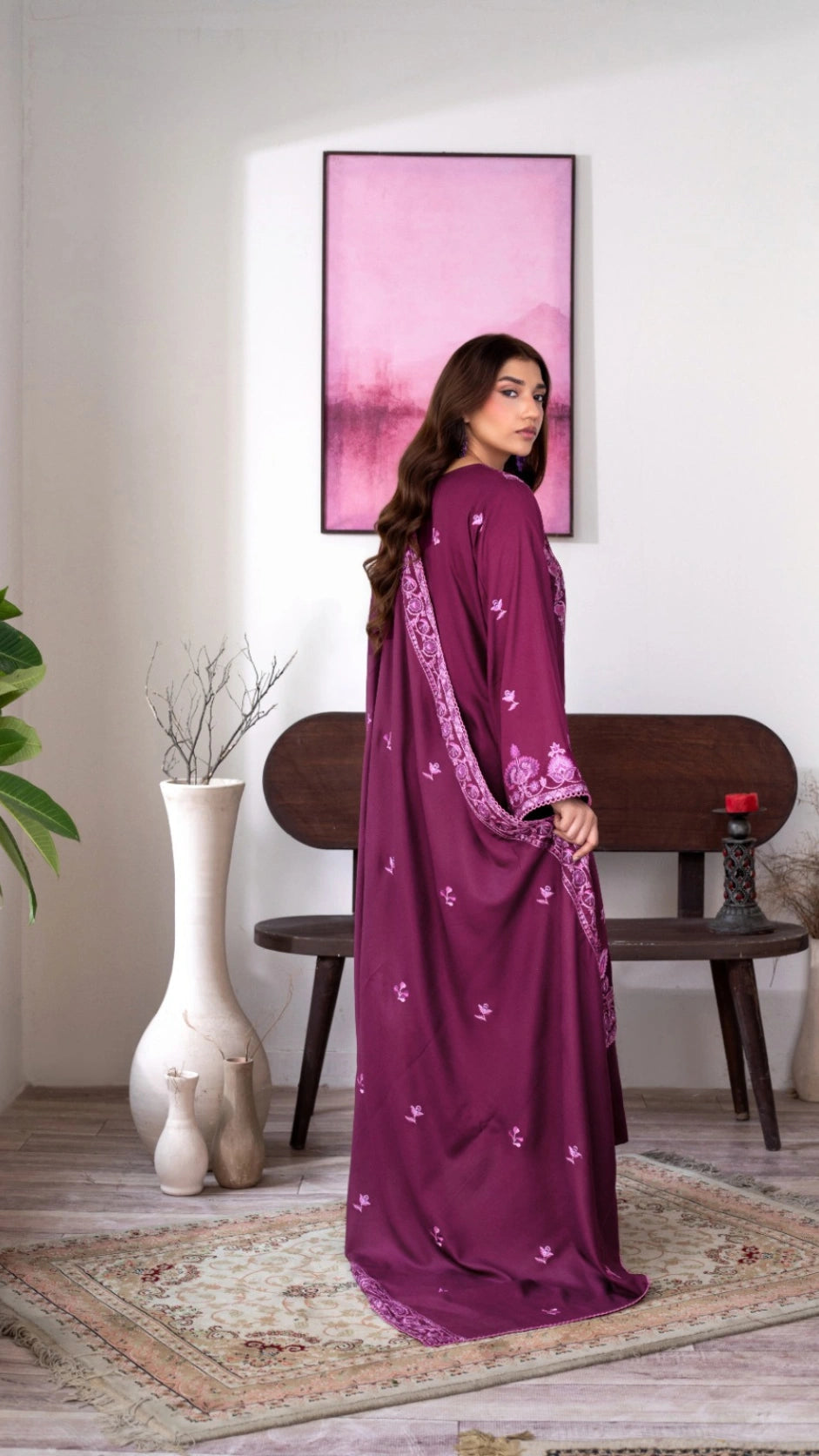 Elegant woman modeling a plum-colored traditional outfit with embroidered details