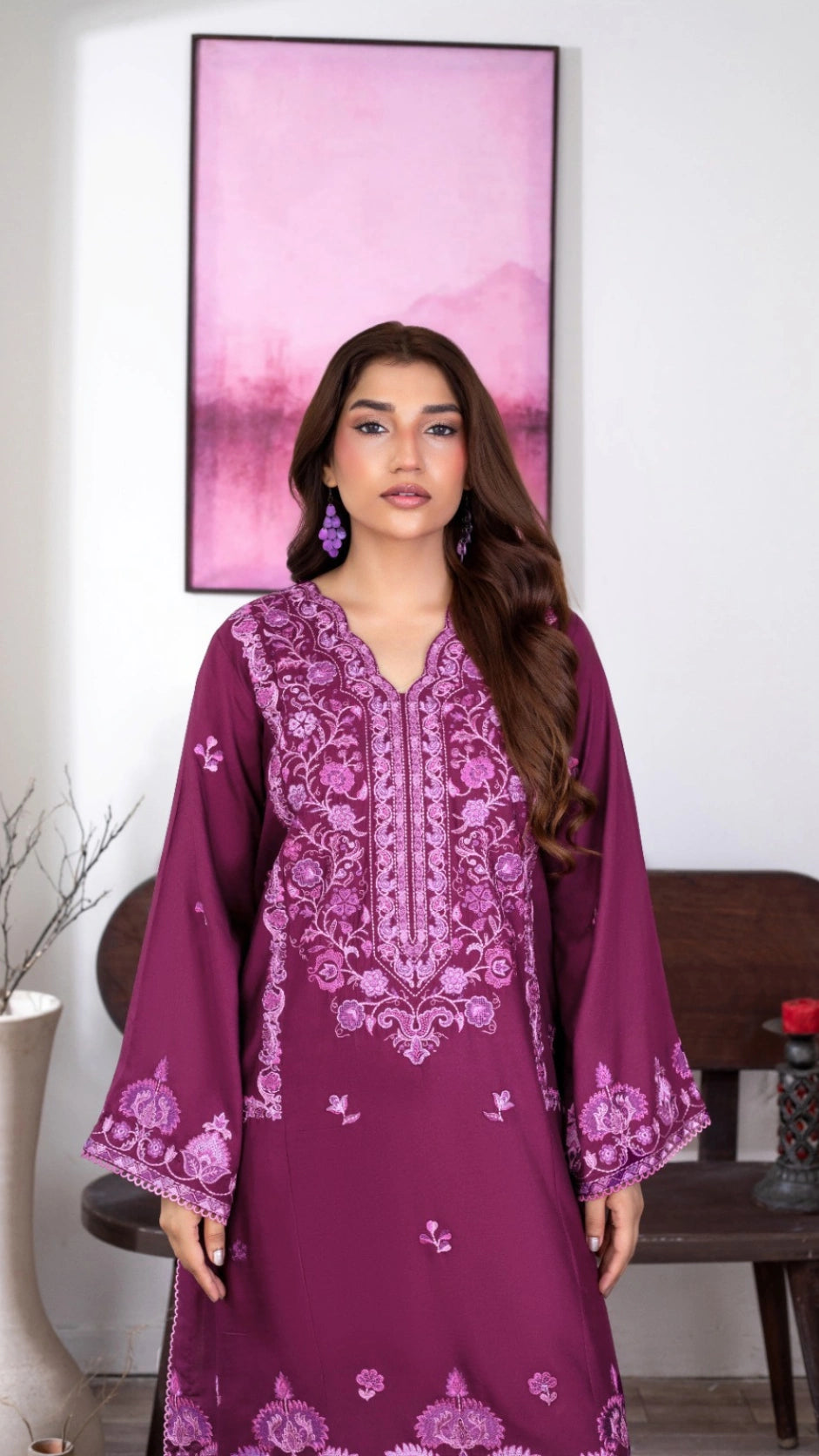 Traditional plum-colored Pakistani dress modeled with intricate floral detailing