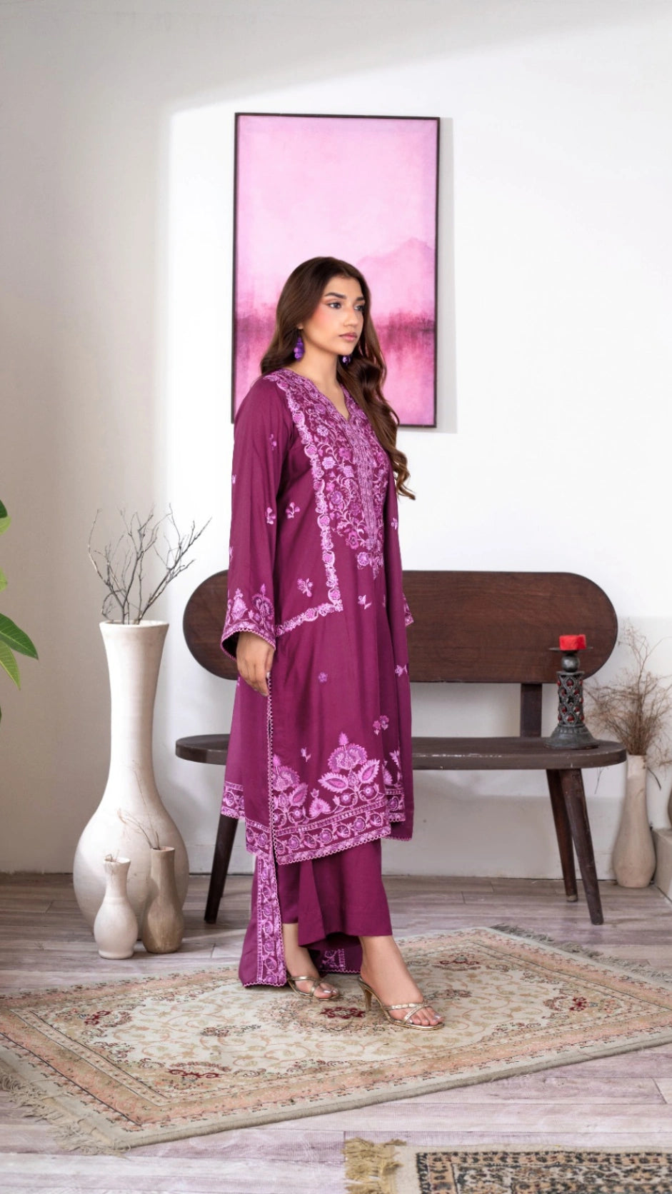 Woman wearing a beautiful plum-colored ethnic outfit with floral embroidery